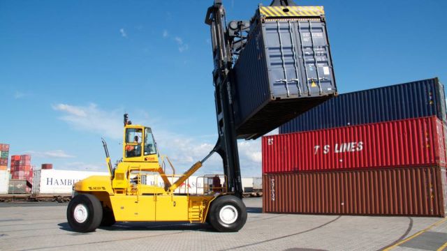 A truck lifting containers at a port.