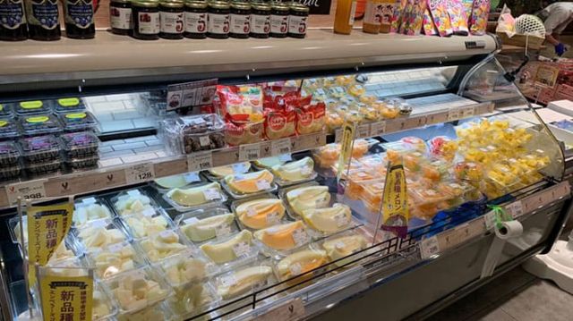 Refrigerated display case of packaged cut fruit in a retail store.